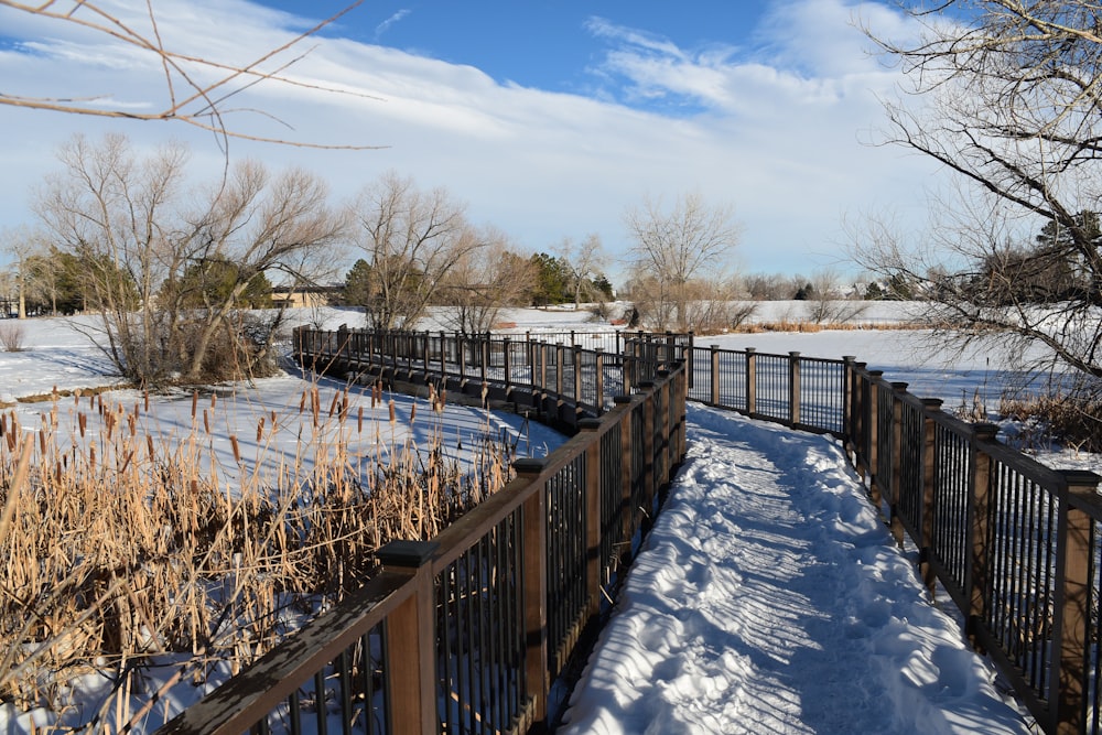 a wooden bridge over a snow covered field