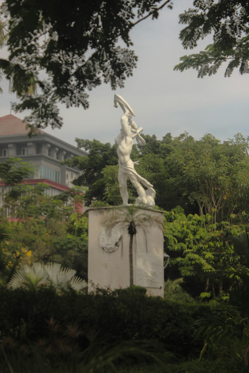 a statue of a woman holding a bird in a park