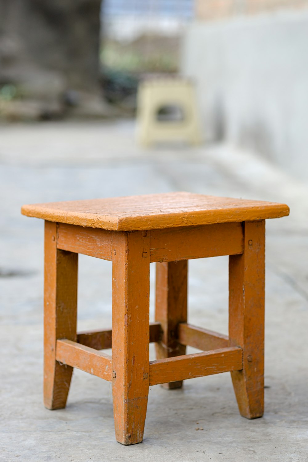 a small wooden table sitting on top of a sidewalk