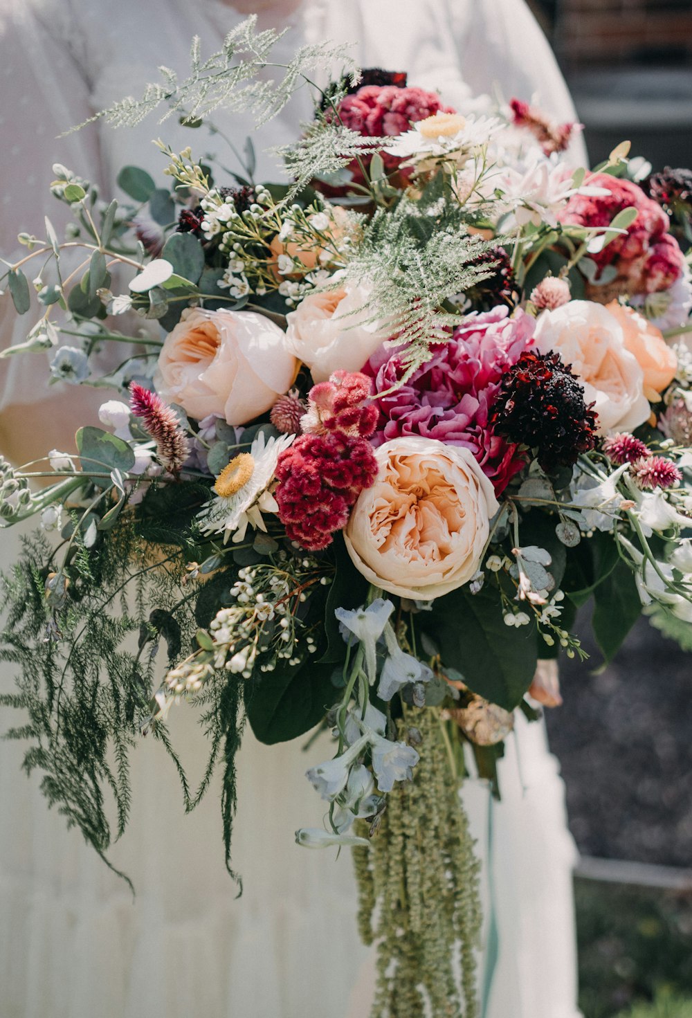 a woman holding a bouquet of flowers in her hands