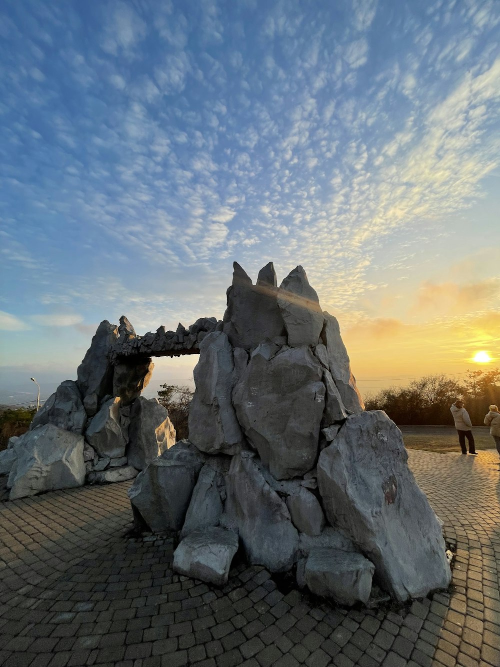 a large rock structure sitting on top of a brick road