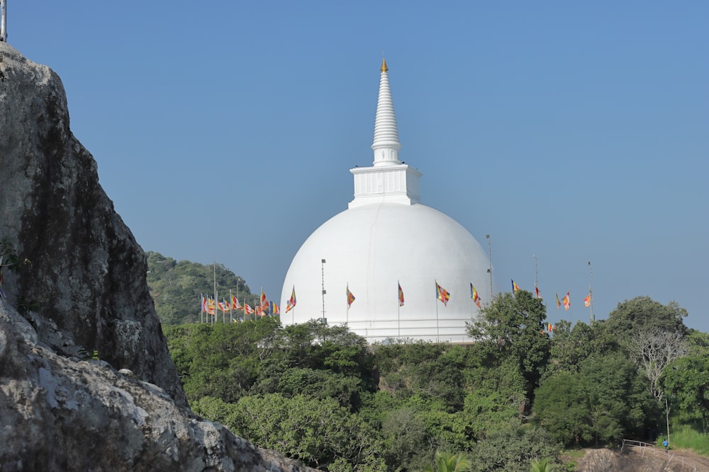 a large white building sitting on top of a lush green hillside