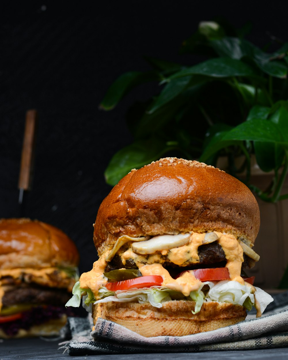 a close up of a sandwich on a napkin near a potted plant