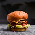A juicy hamburger with lettuce and tomato on a rustic background.
