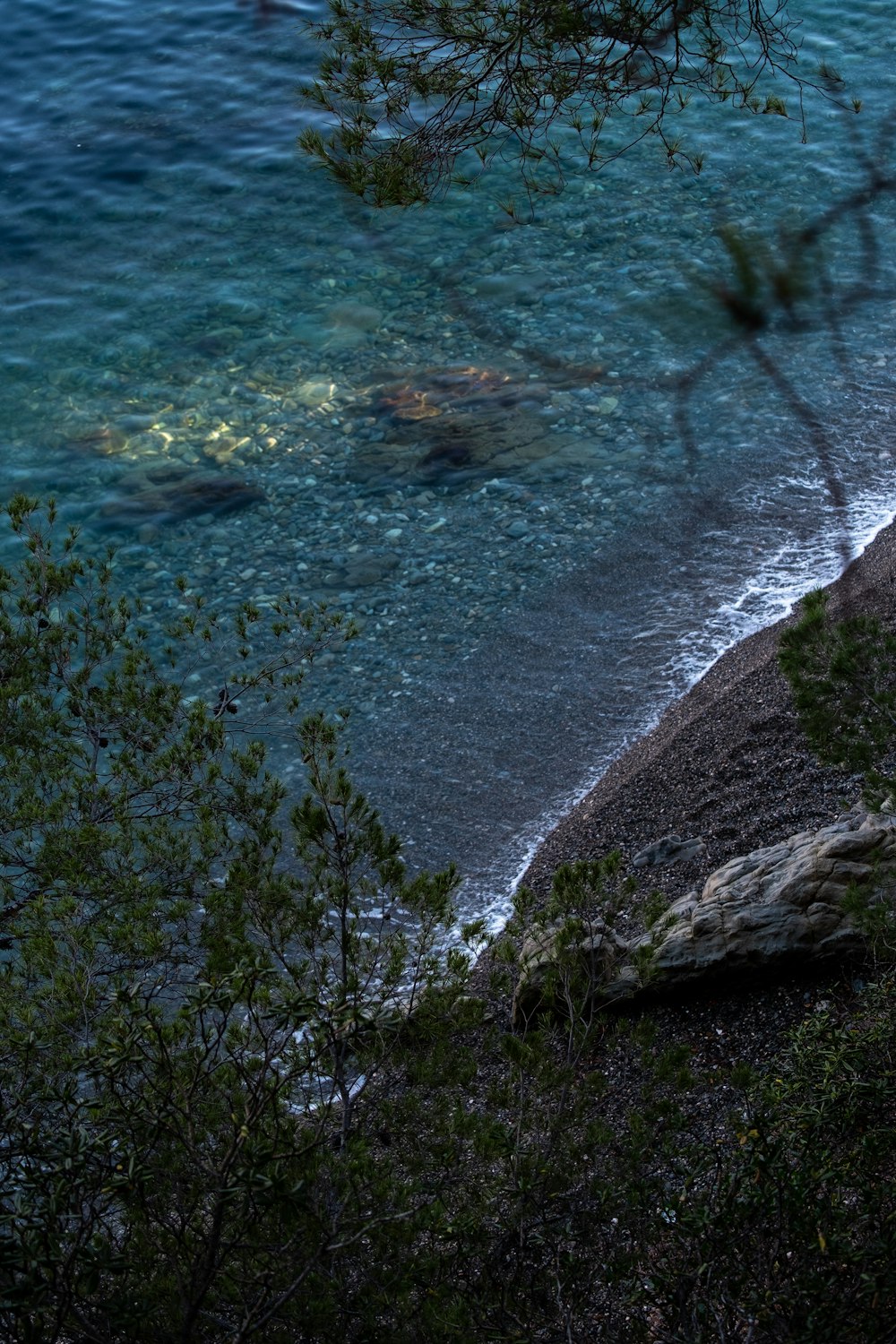 a body of water next to a rocky shore