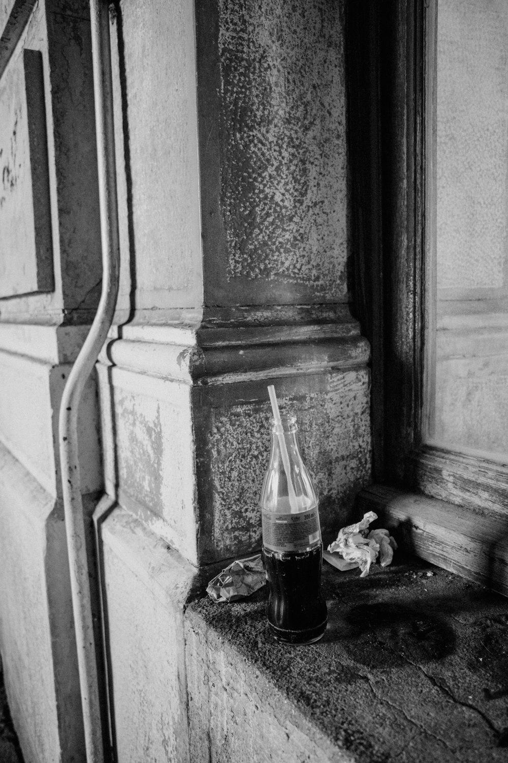 a black and white photo of a bottle and a cigarette