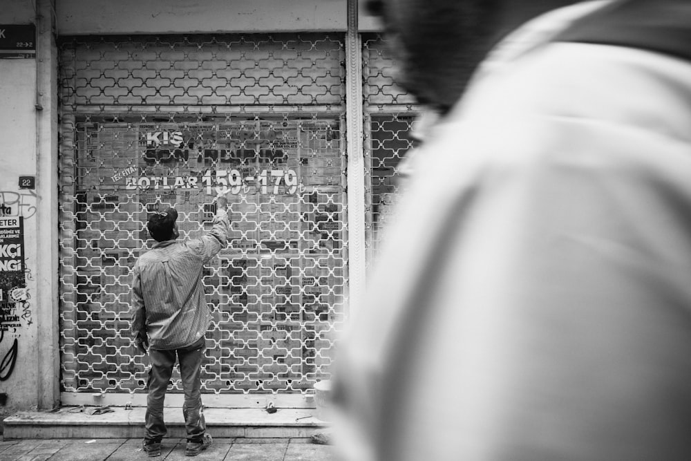 a man standing in front of a building with graffiti on it