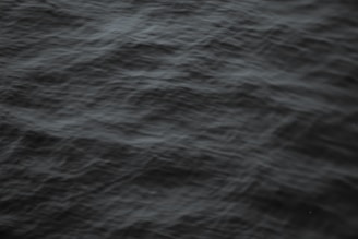 Close-up of dark crude oil waves gently rippling under soft light.