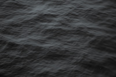Close-up of dark crude oil waves gently rippling under soft light.