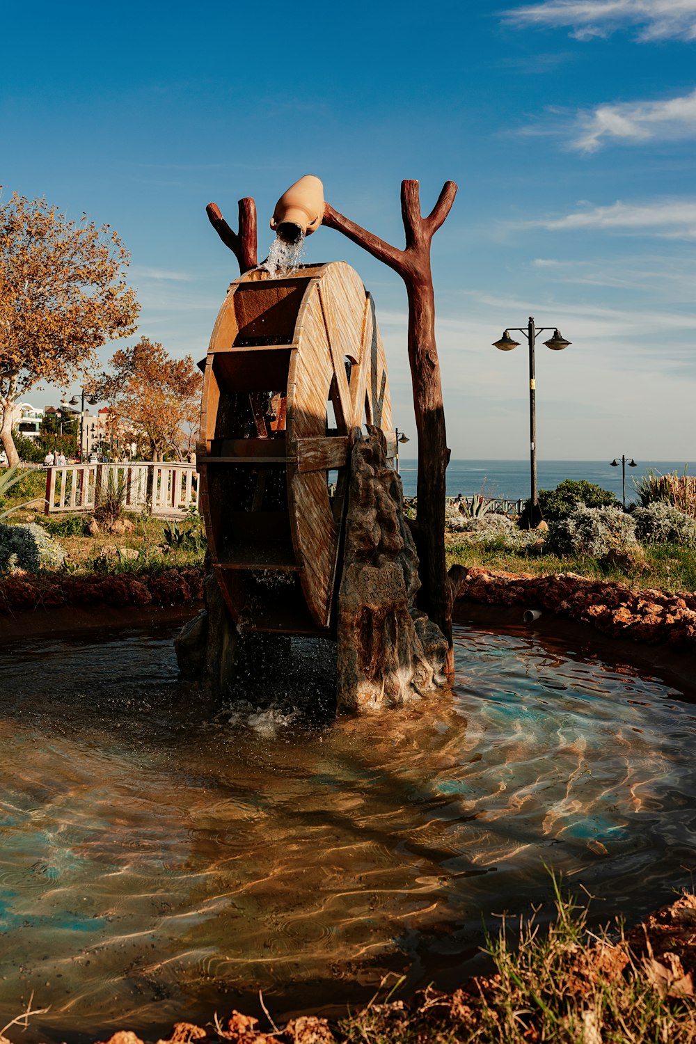 a statue of a man sitting on top of a wooden boat