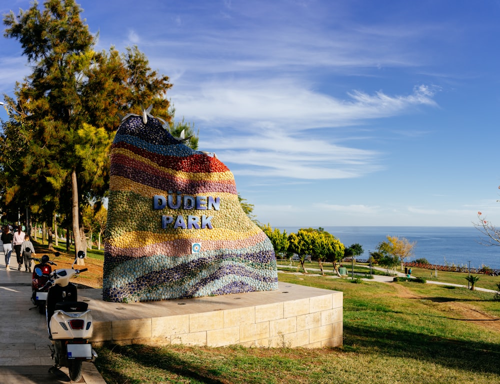 a motorcycle parked in front of a large piece of art