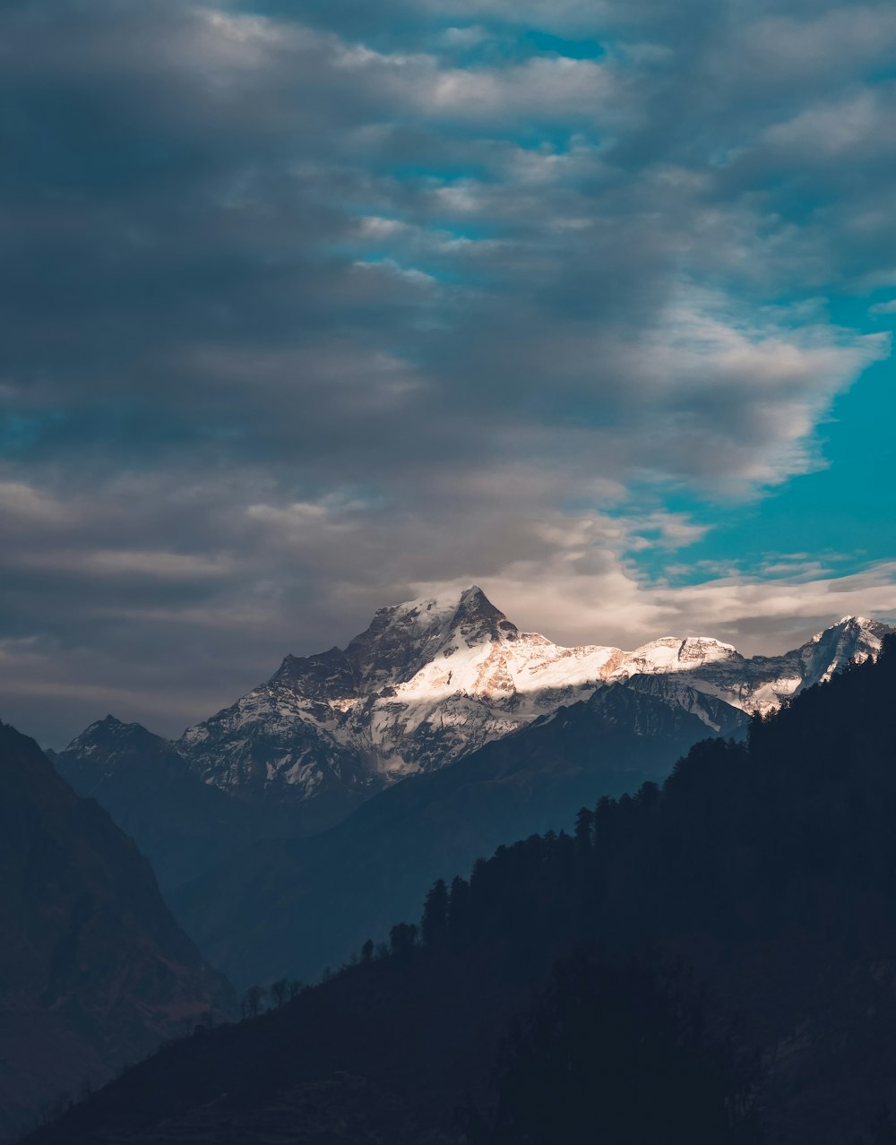 a view of a mountain range with clouds in the sky