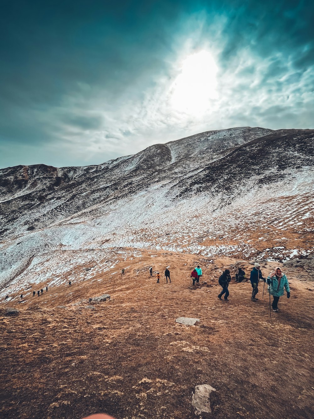 a group of people walking up a snow covered hill