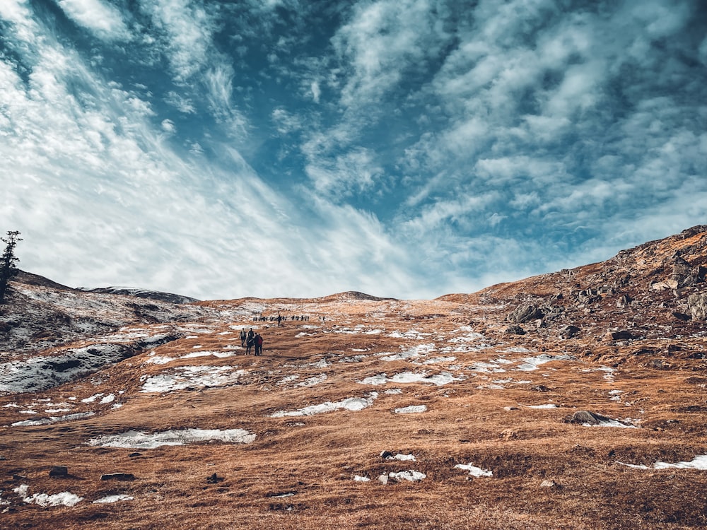 a couple of people standing on top of a snow covered slope