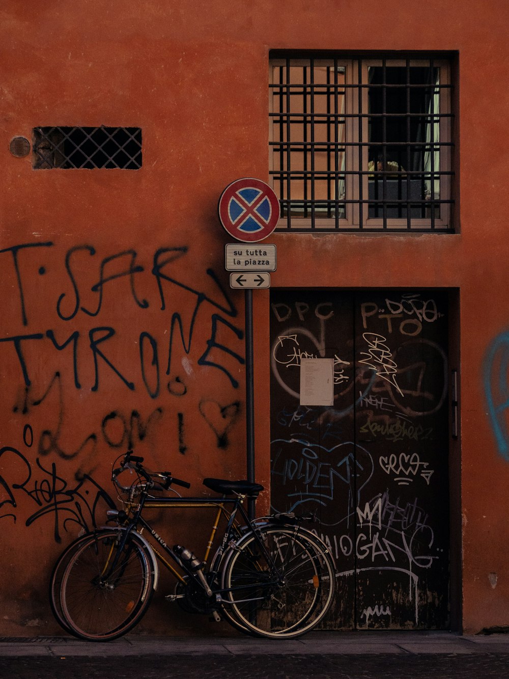 a bike parked next to a building with graffiti on it