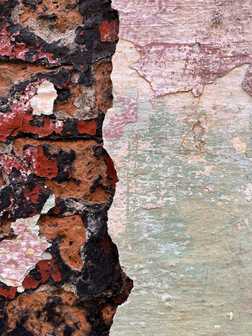 a close up of a brick wall with peeling paint