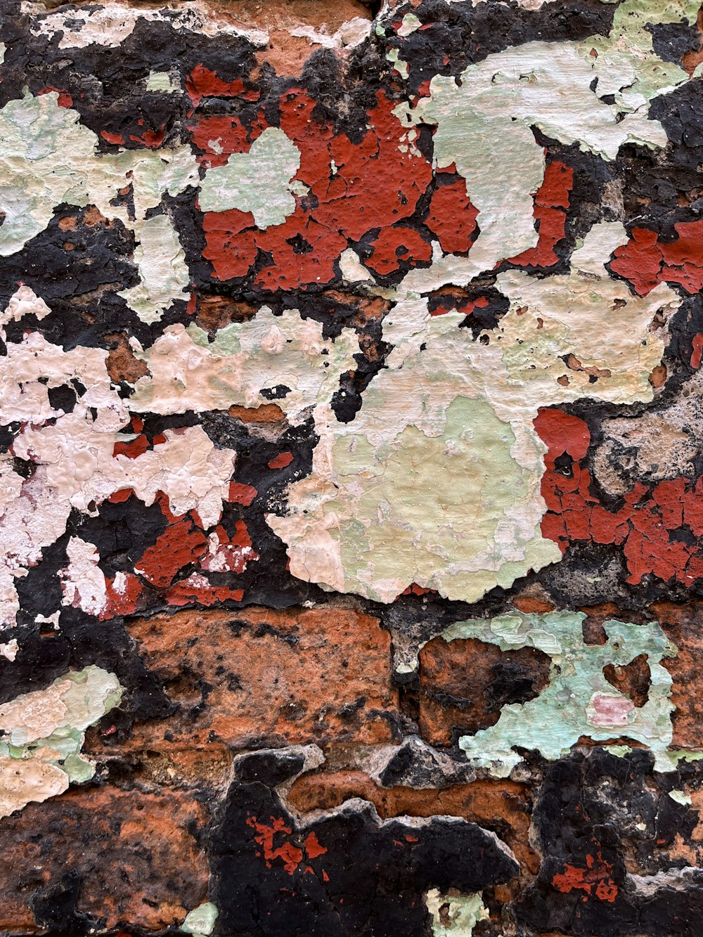 a close up of a brick wall with peeling paint