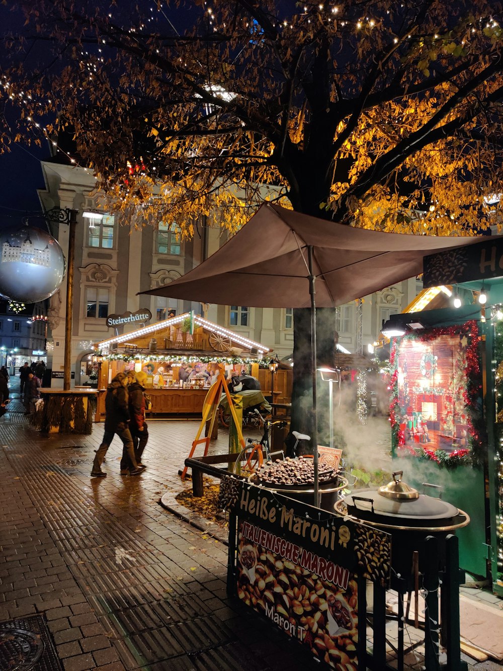 a person walking down a street next to a food stand