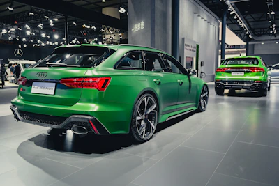Audi RS6 elegantly positioned on a winding road surrounded by lush greenery.