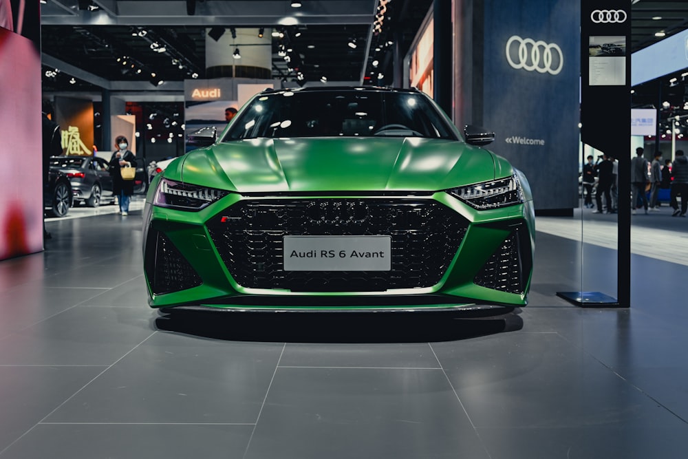 a green sports car on display at a car show