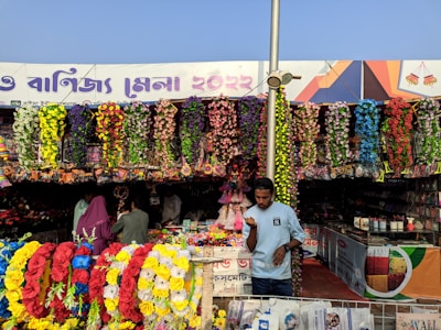 A vibrant stall at the Flower Mela bursting with colorful blooms and smiling visitors.