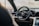 A luxurious car interior featuring a sleek, modern dashboard with a digital display and a prominent steering wheel bearing the Porsche logo. The design boasts premium materials and a sophisticated aesthetic.