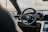 A luxurious car interior featuring a sleek, modern dashboard with a digital display and a prominent steering wheel bearing the Porsche logo. The design boasts premium materials and a sophisticated aesthetic.