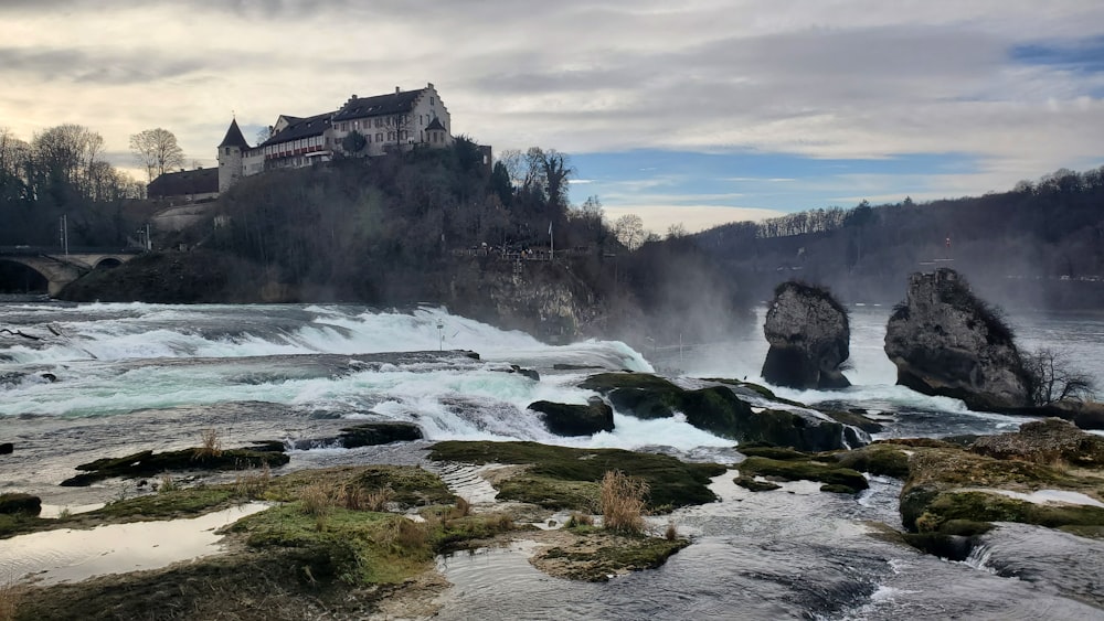 a castle on top of a hill next to a river