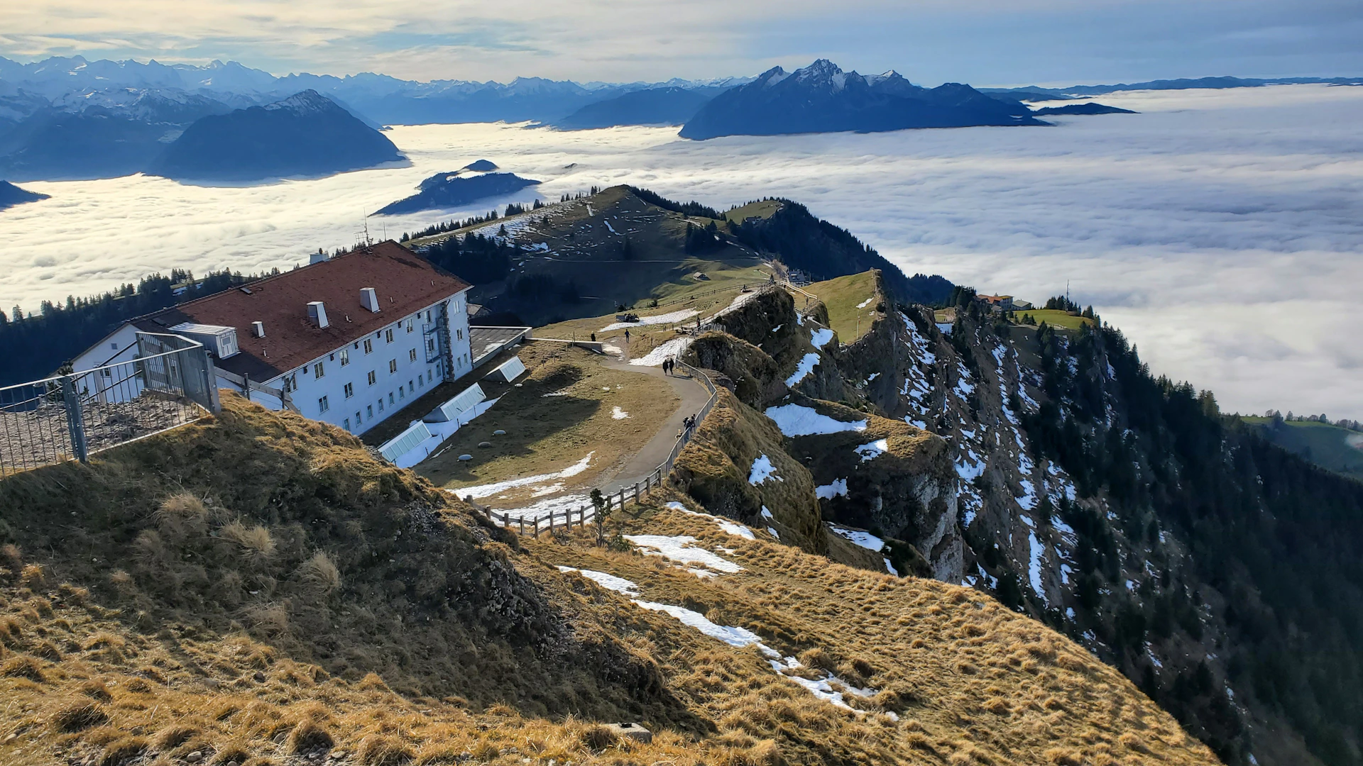 a house on top of a mountain surrounded by clouds
