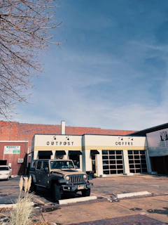 The Onyx Coffee Jeep parked on a sunny street corner with customers chatting nearby.