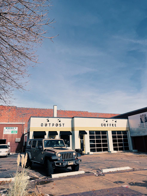 The Onyx Coffee Jeep parked on a sunny street corner with customers chatting nearby.