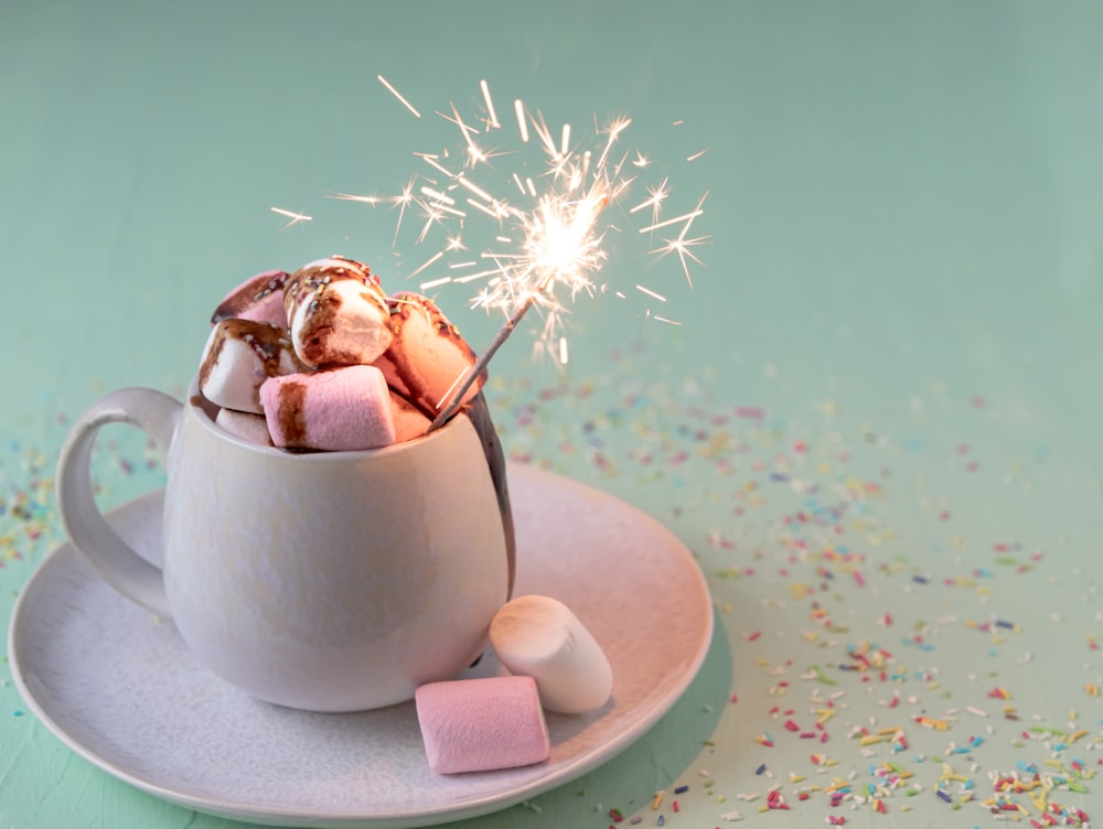 a cup filled with marshmallows and a sparkler