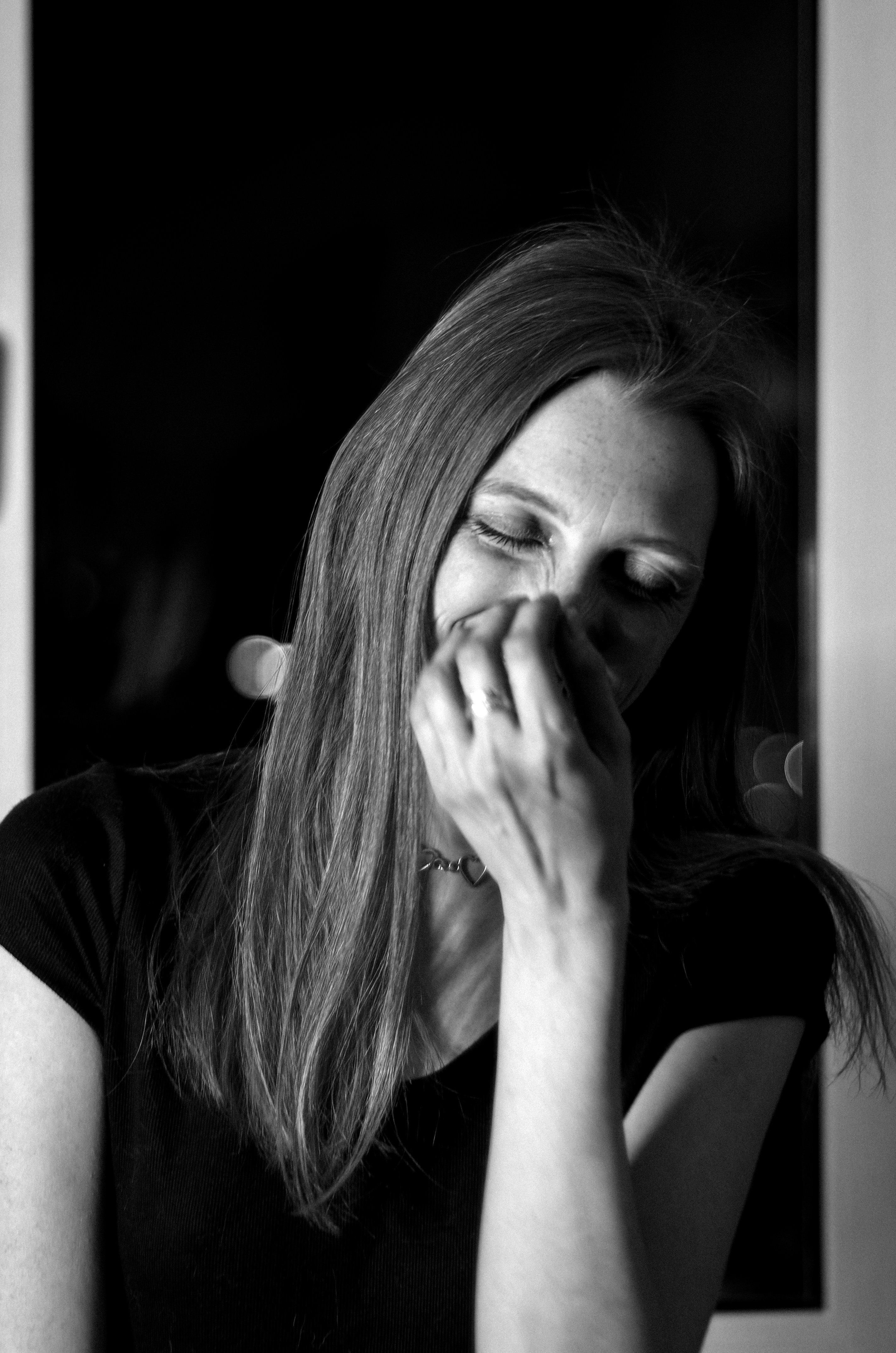 Black and white photo of a woman covering her mouth