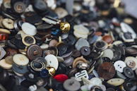 A collection of vintage-style buttons made from metal and polyester.