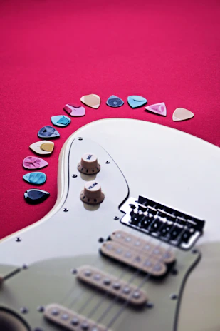A vibrant electric guitar with colorful inlays displayed against a rustic background.