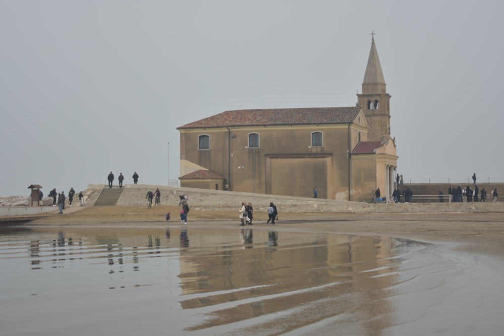 a group of people standing on a beach next to a building