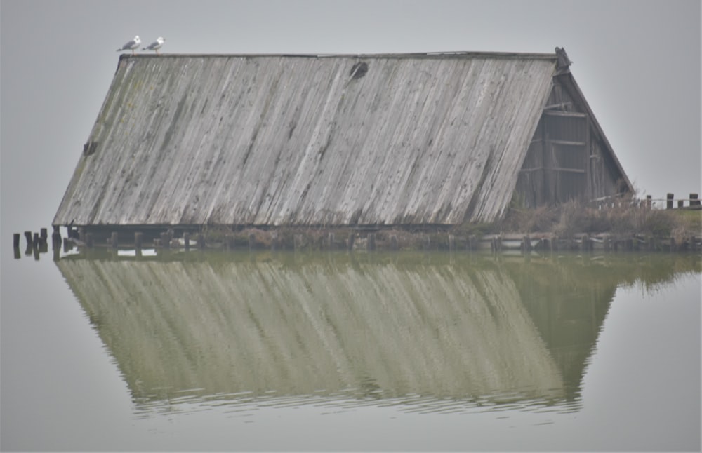 a barn sitting on top of a body of water