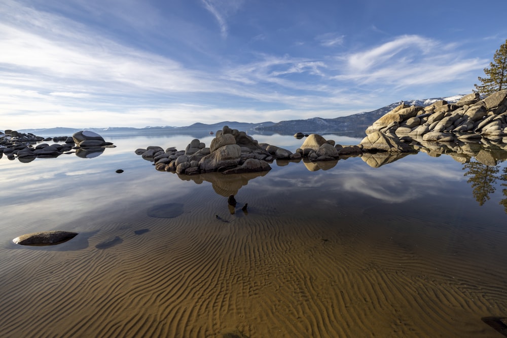 a body of water surrounded by rocks and trees