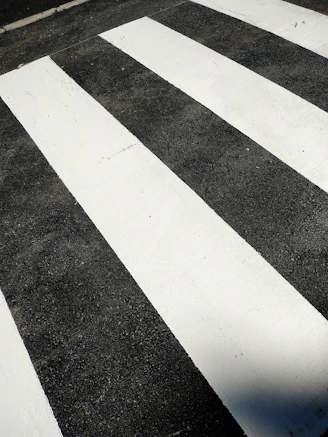 a person riding a skateboard across a crosswalk