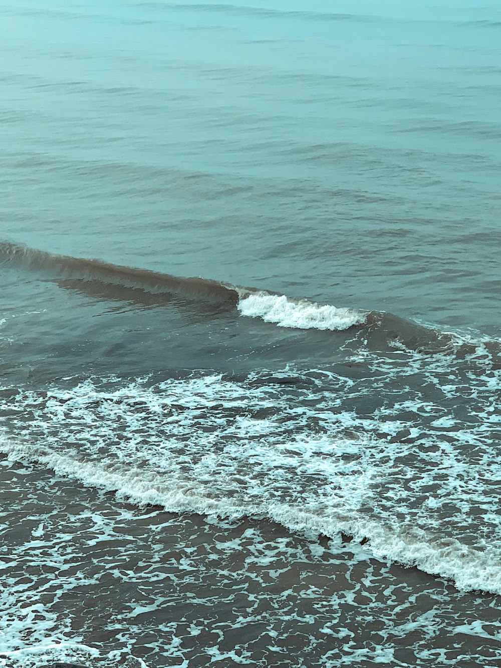 Un homme sur une planche de surf au sommet d’une vague dans l’océan