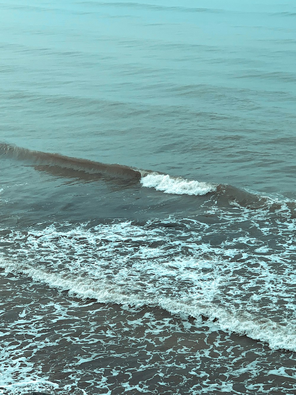 a man riding a surfboard on top of a wave in the ocean