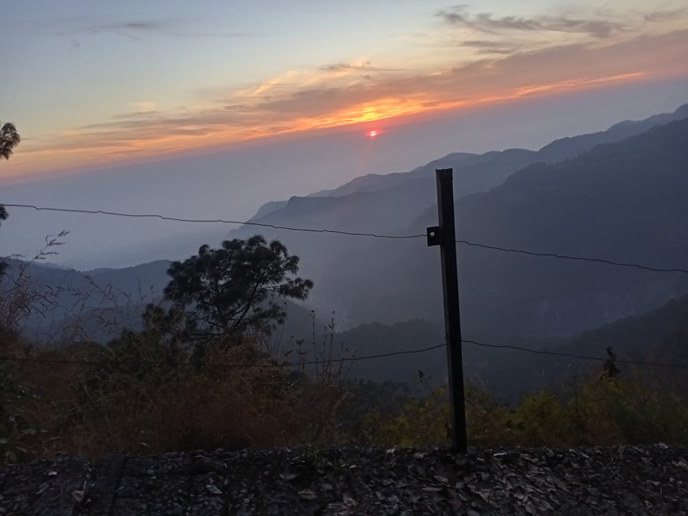 the sun is setting over a mountain range