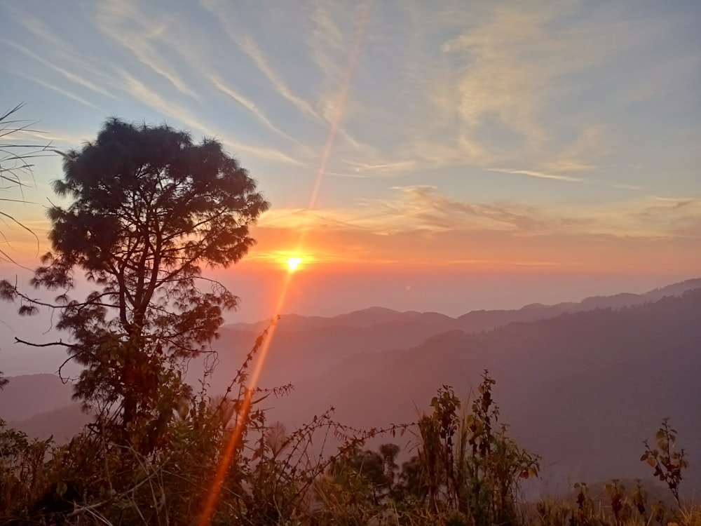 the sun is setting over a mountain range