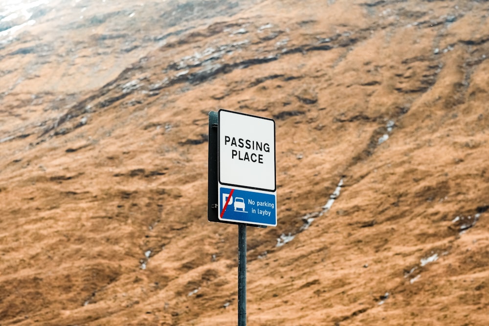 a sign on a pole in front of a mountain