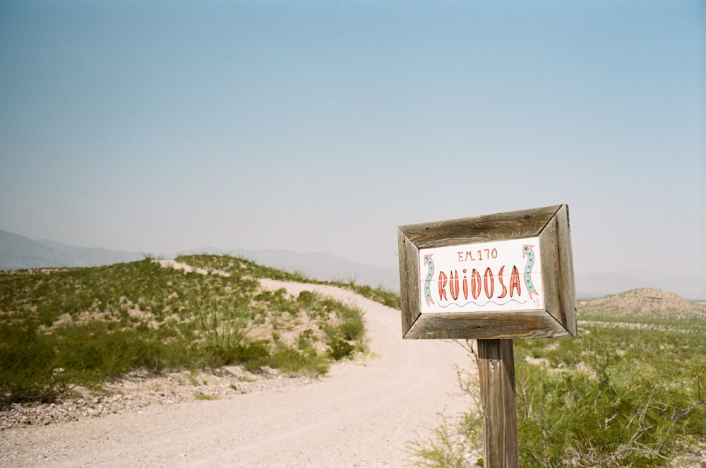 a sign on the side of a dirt road
