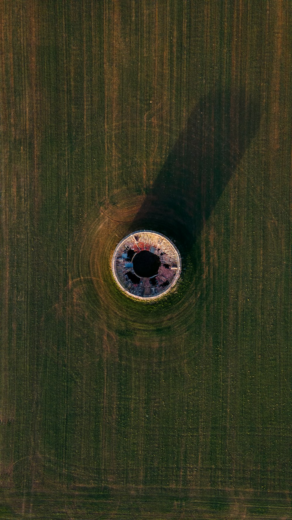 an aerial view of a circular hole in a field