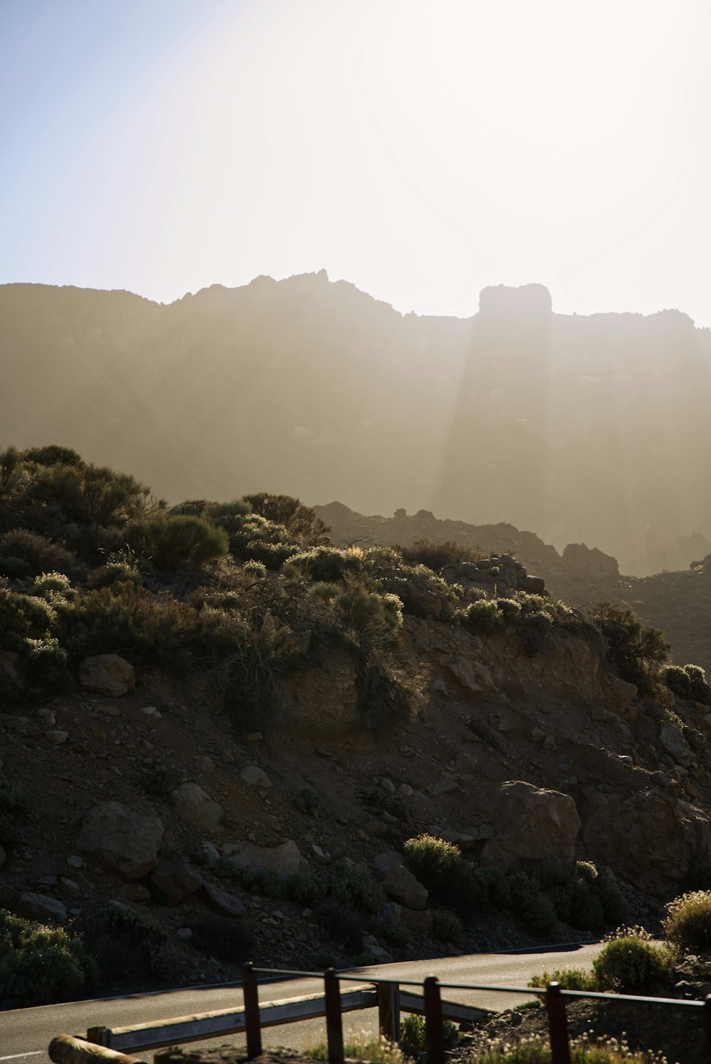 the sun shines on a rocky mountain side