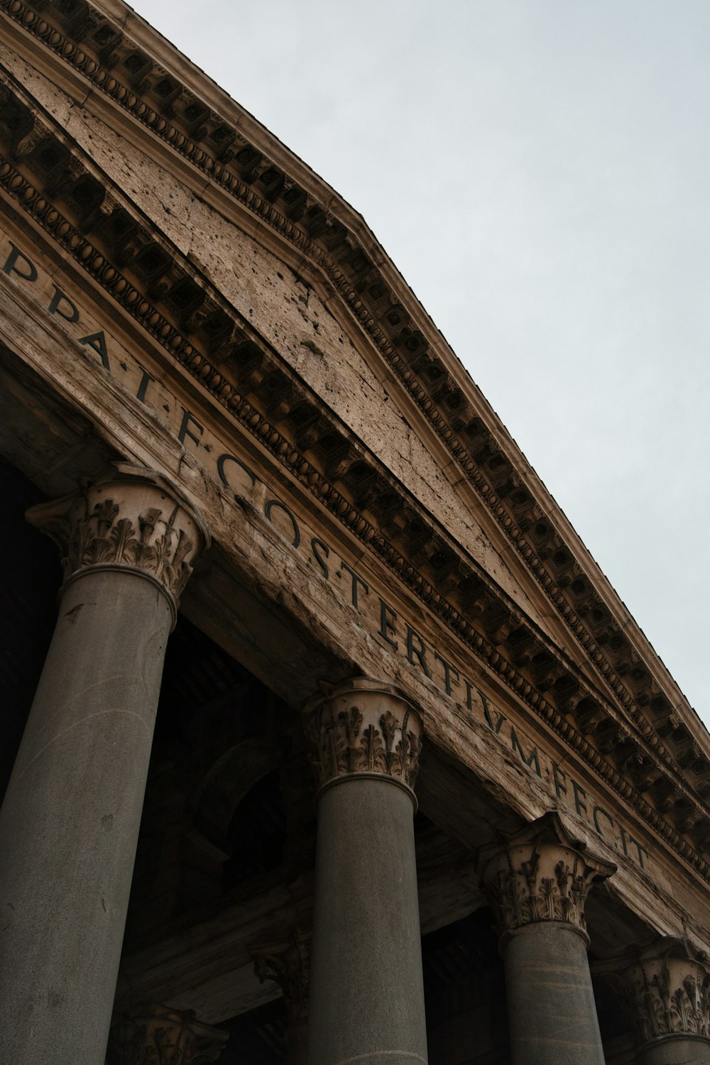 a building with columns and a clock on the side of it