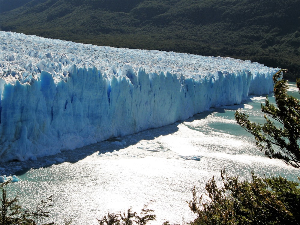 a large glacier wall in the middle of a body of water