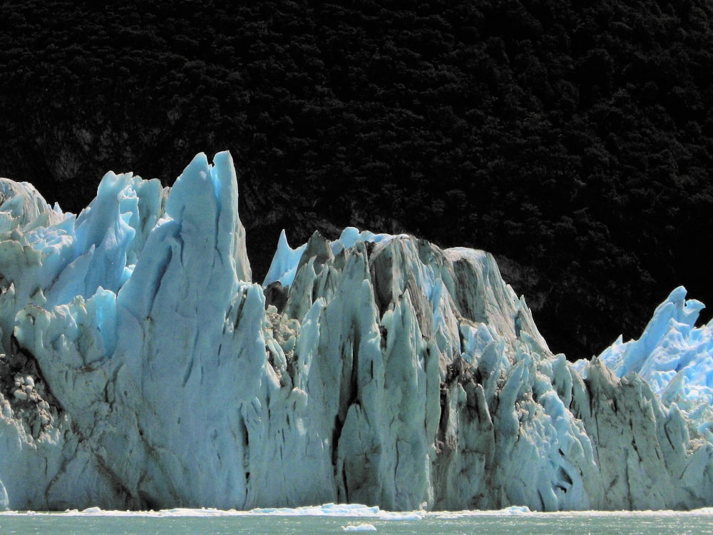 a very tall iceberg towering over a body of water